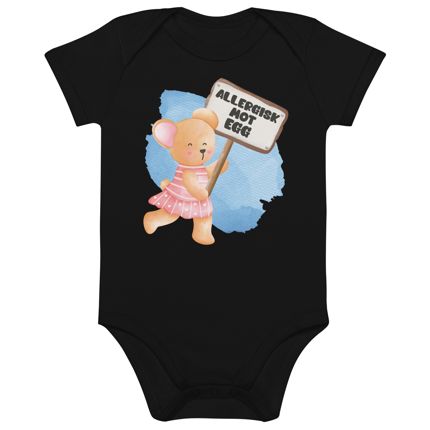 Svart babybody som ligger flatt, med en glad bamse som holder oppe et skilt med teksten "Allergisk mot egg". Foto.