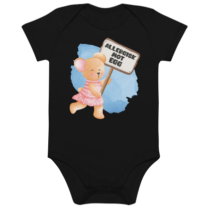 Svart babybody som ligger flatt, med en glad bamse som holder oppe et skilt med teksten "Allergisk mot egg". Foto.