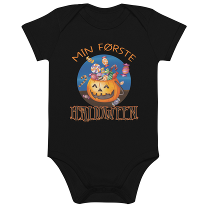 Svart babybody som ligger flatt, med teksten "Min første halloween" og figur av en kurv som ser ut som et gresskar og som er fylt med godteri. Foto.