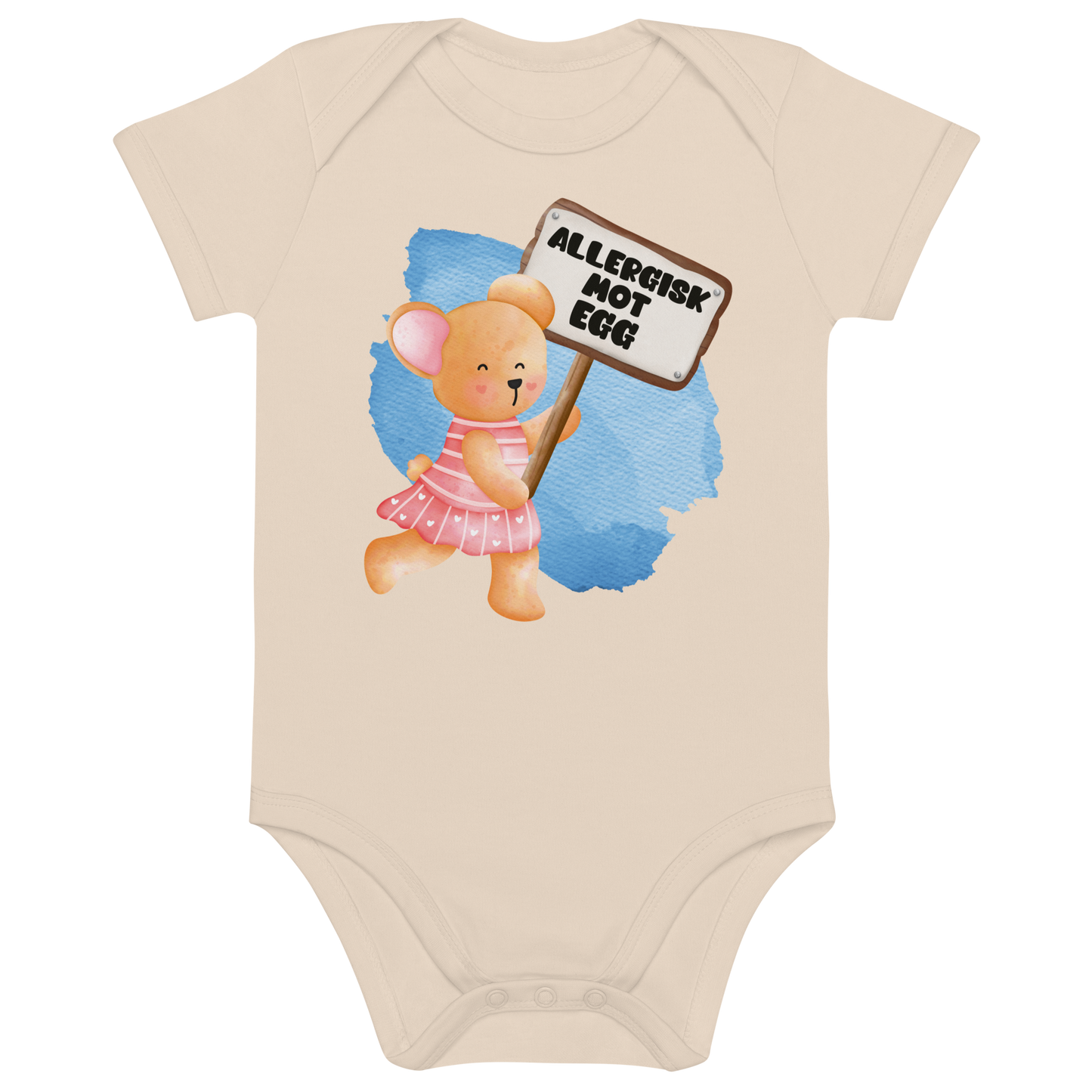 Beige babybody som ligger flatt, med en glad bamse som holder oppe et skilt med teksten "Allergisk mot egg". Foto.