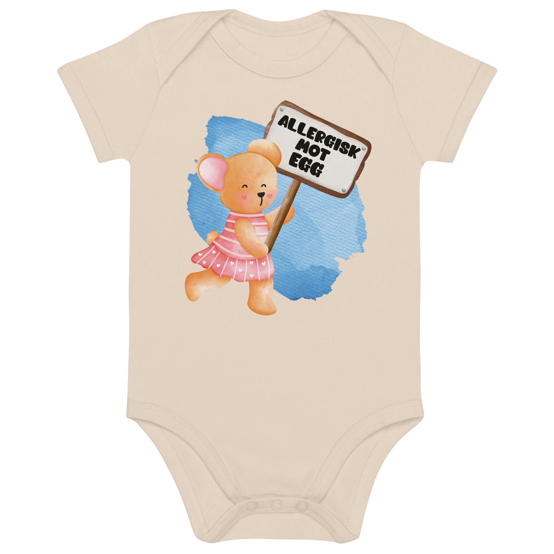 Beige babybody som ligger flatt, med en glad bamse som holder oppe et skilt med teksten "Allergisk mot egg". Foto.