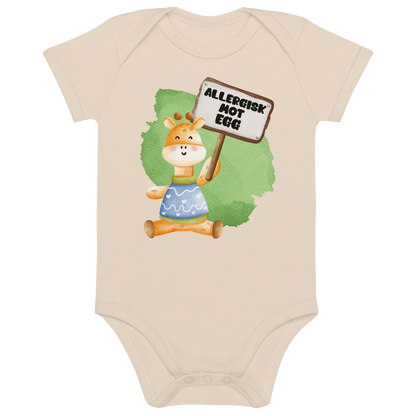 Beige babybody som ligger flatt, med en glad sjiraff som holder oppe et skilt med teksten "Allergisk mot egg". Foto.