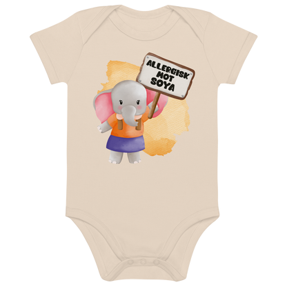 Beige babybody som ligger flatt, med en glad elefant som holder oppe et skilt med teksten "Allergisk mot soya". Foto.