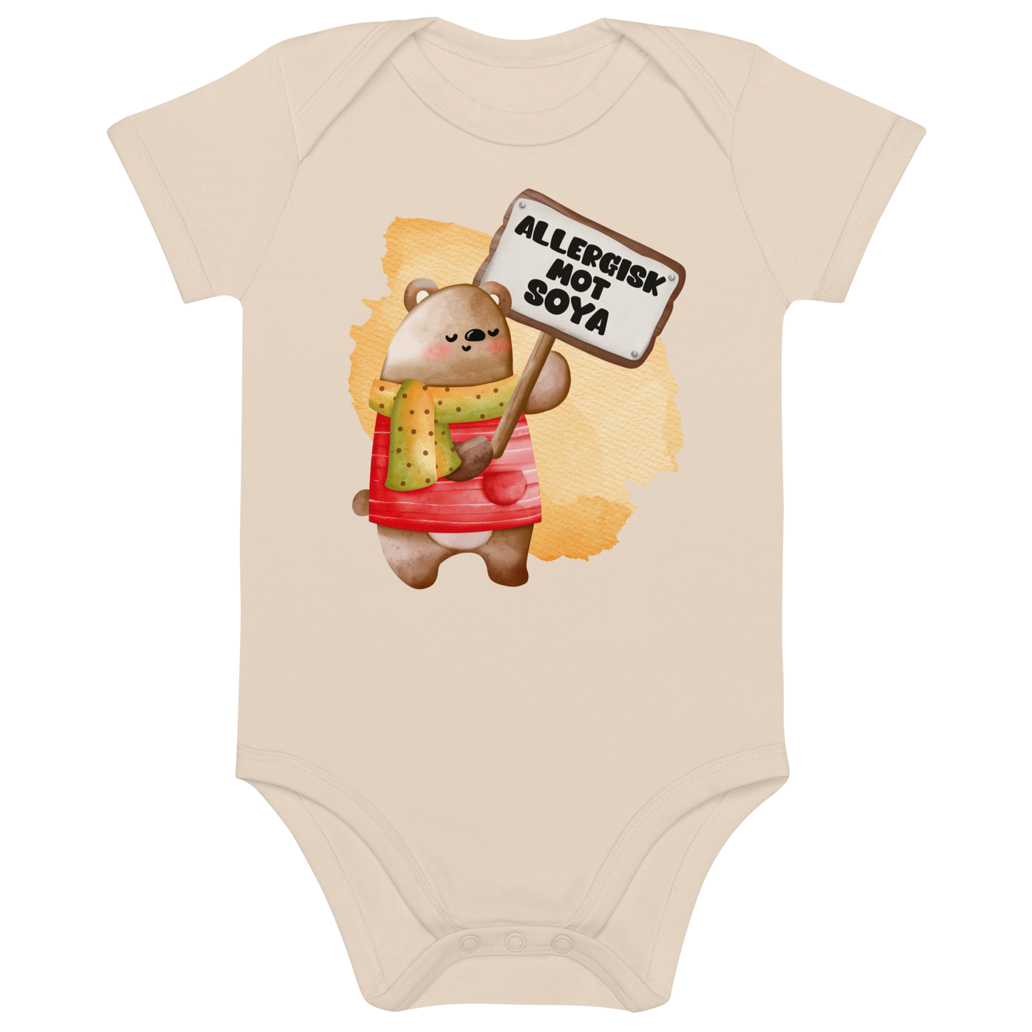 Beige babybody som ligger flatt, med en glad bamse som holder oppe et skilt med teksten "Allergisk mot soya". Foto.