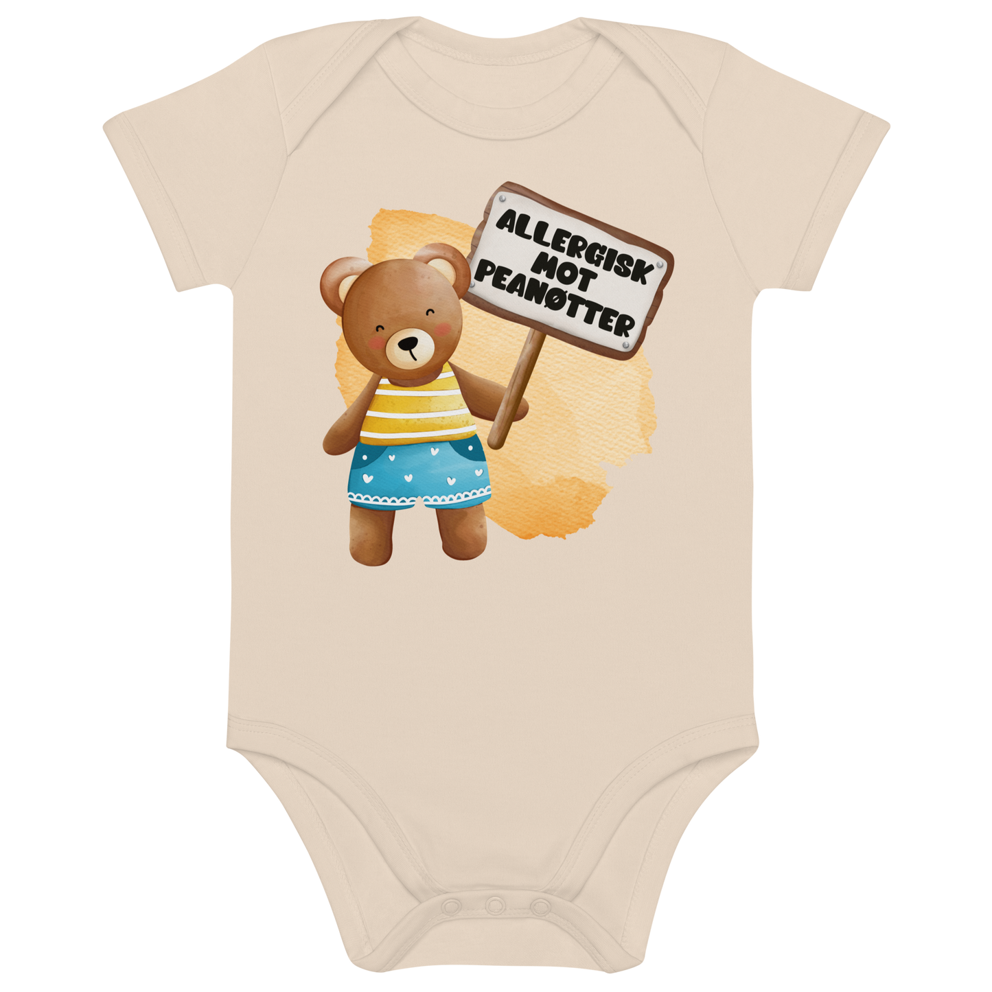 Beige babybody som ligger flatt, med en glad bamse som holder oppe et skilt med teksten "Allergisk mot peanøtter". Foto.