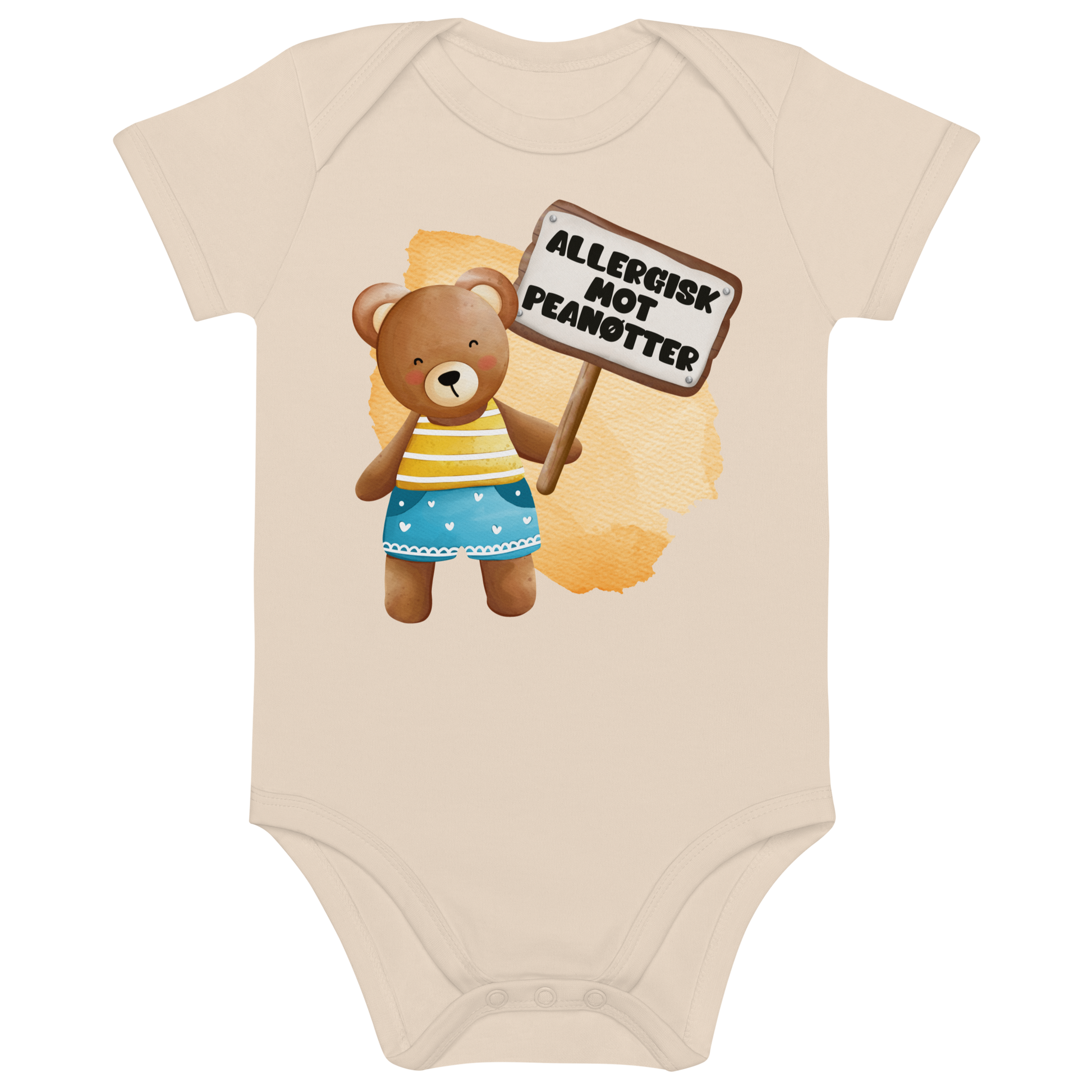 Beige babybody som ligger flatt, med en glad bamse som holder oppe et skilt med teksten "Allergisk mot peanøtter". Foto.