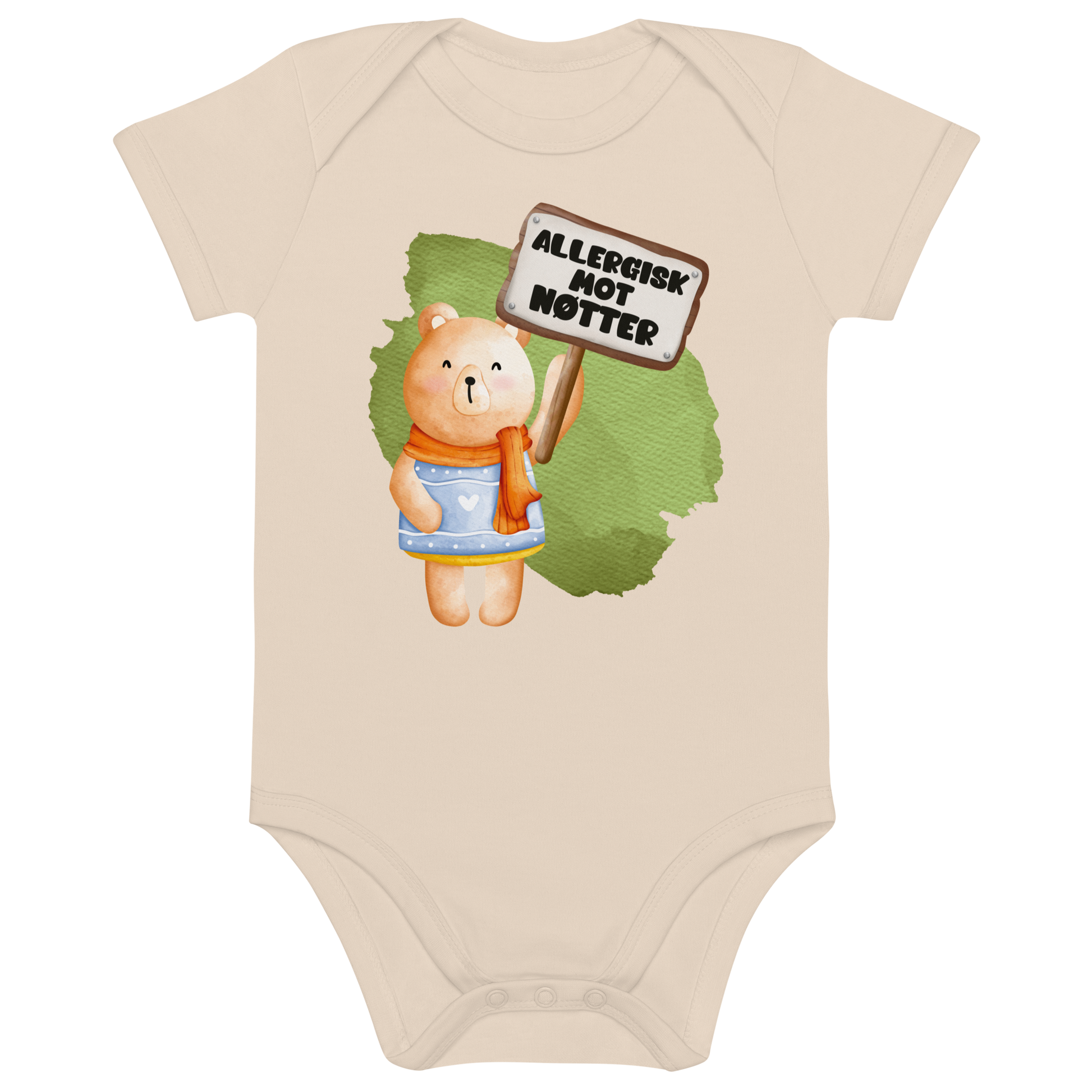 Beige babybody som ligger flatt, med en glad bamse som holder oppe et skilt med teksten "Allergisk mot nøtter". Foto.