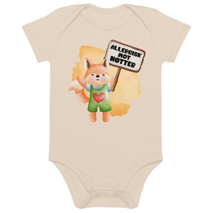 Beige babybody som ligger flatt, med en glad rev som holder oppe et skilt med teksten "Allergisk mot nøtter". Foto.