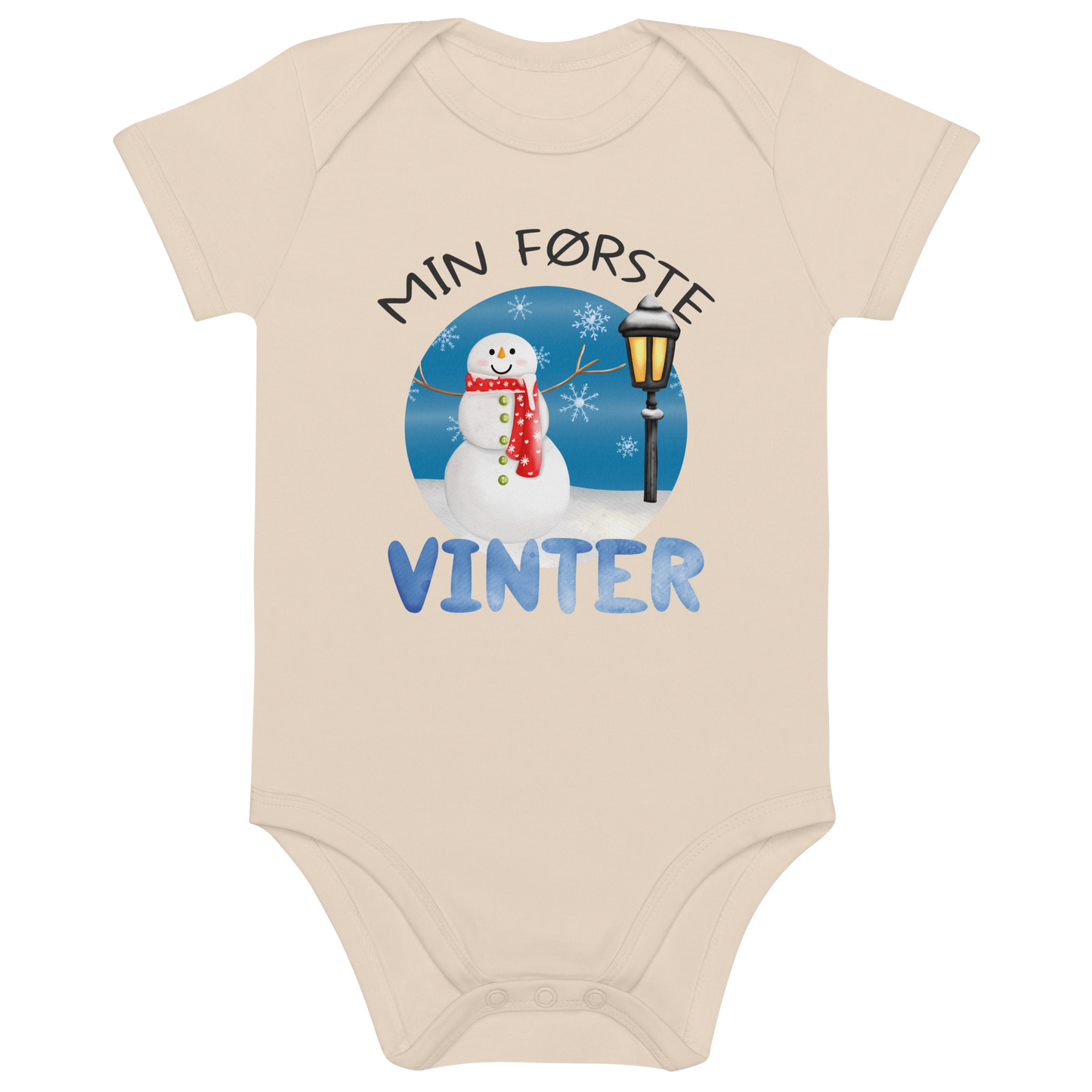 Beige babybody som ligger flatt, med teksten "Min første vinter" og figur av en glad snømann ved en gammeldags lyktestolpe. Foto.