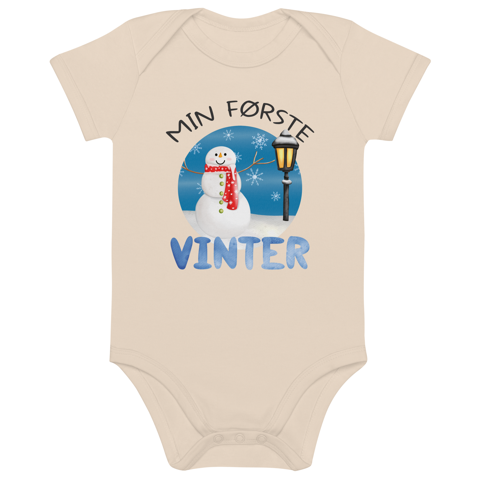 Beige babybody som ligger flatt, med teksten "Min første vinter" og figur av en glad snømann ved en gammeldags lyktestolpe. Foto.