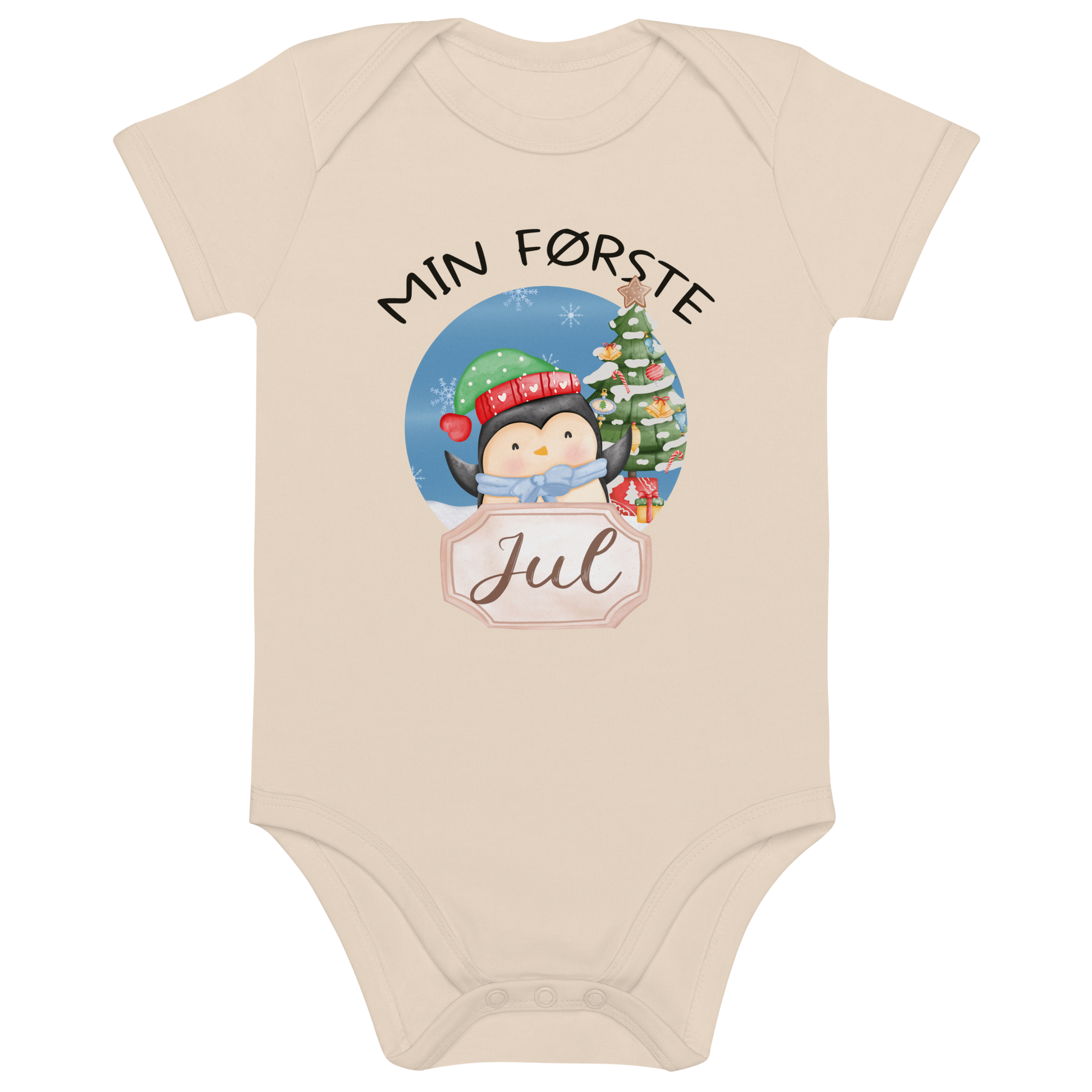 Beige babybody som ligger flatt, med teksten "Min første jul" og figur av en glad pingvin med nisselue og skjerf foran et juletre. Foto.