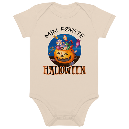Beige babybody som ligger flatt, med teksten "Min første halloween" og figur av en kurv som ser ut som et gresskar og som er fylt med godteri. Foto.