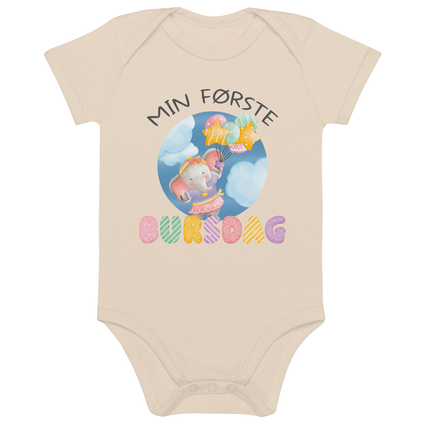 Beige babybody som ligger flatt, med teksten "Min første bursdag" og figur av en søt og glad elefant som holder flere ballonger og flyr mellom skyene. Foto.