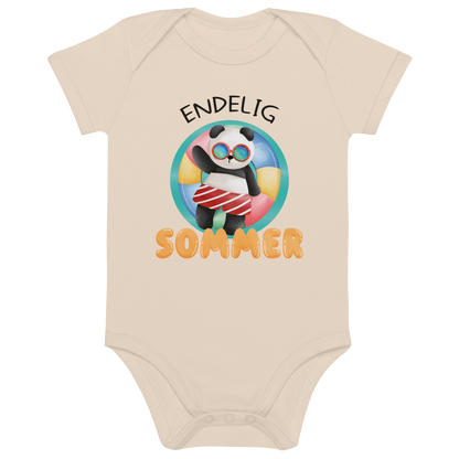 Beige babybody som ligger flatt, med teksten "Endelig sommer" og figur av en avslappet panda med solbriller som flyter i vannet på en badering. Foto.