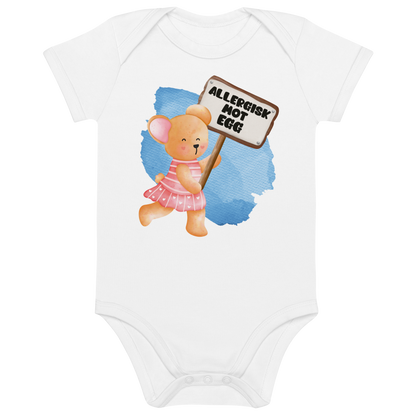 Hvit babybody som ligger flatt, med en glad bamse som holder oppe et skilt med teksten "Allergisk mot egg". Foto.