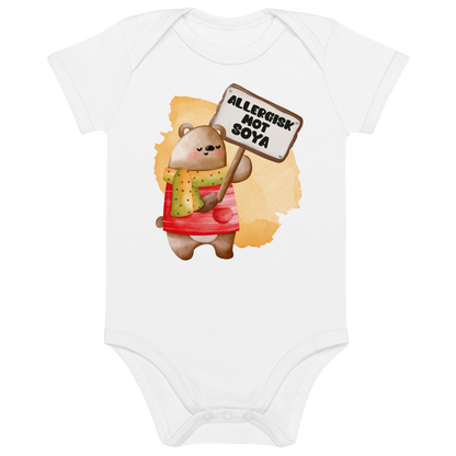 Hvit babybody som ligger flatt, med en glad bamse som holder oppe et skilt med teksten "Allergisk mot soya". Foto.