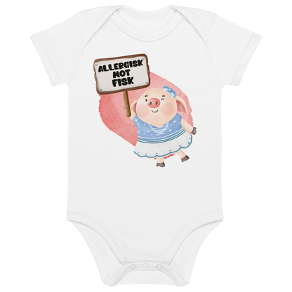 Hvit babybody som ligger flatt, med en glad gris som holder oppe et skilt med teksten "Allergisk mot fisk". Foto.
