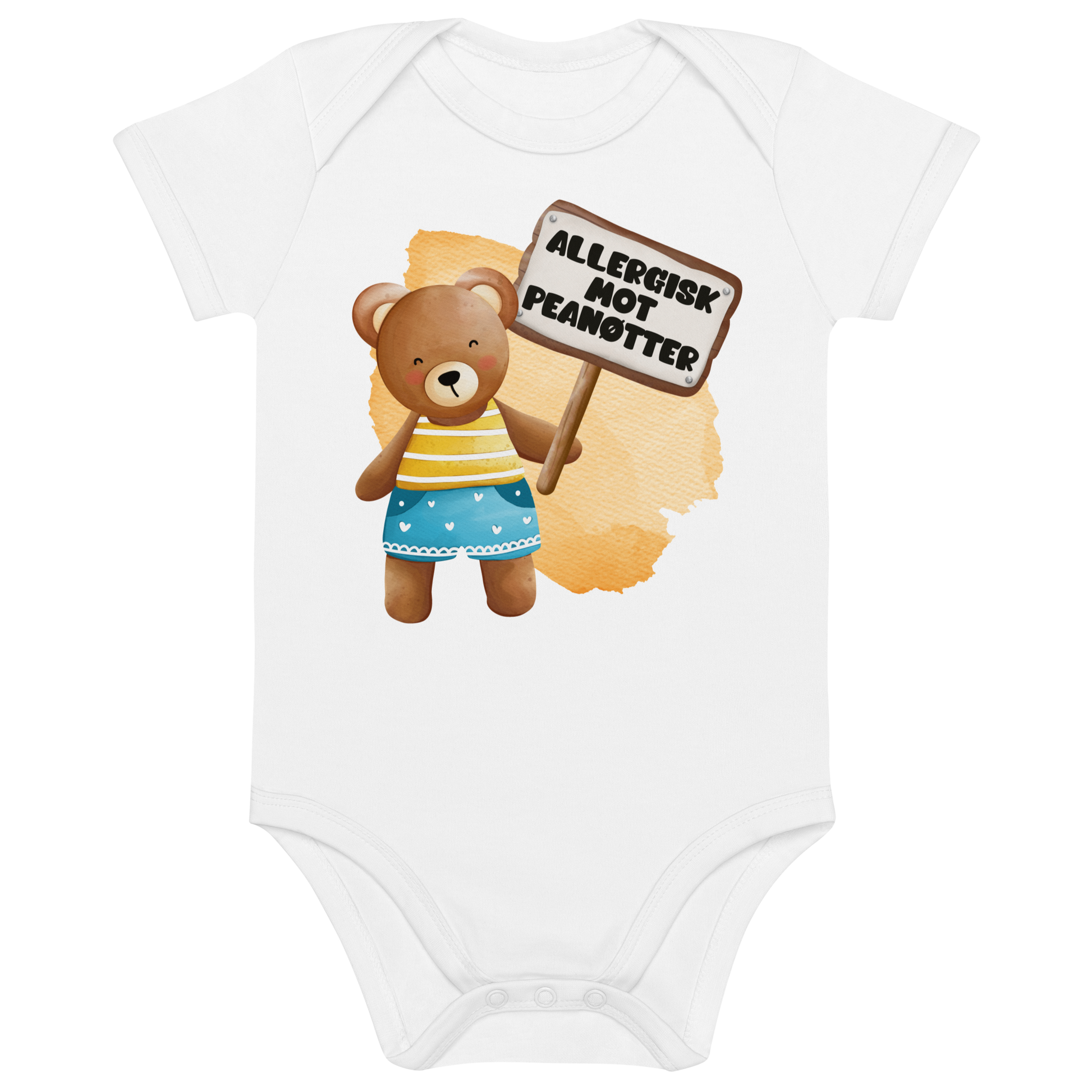 Hvit babybody som ligger flatt, med en glad bamse som holder oppe et skilt med teksten "Allergisk mot peanøtter". Foto.