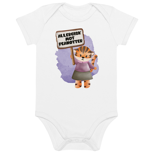 Hvit babybody som ligger flatt, med en glad tiger som holder oppe et skilt med teksten "Allergisk mot peanøtter". Foto.