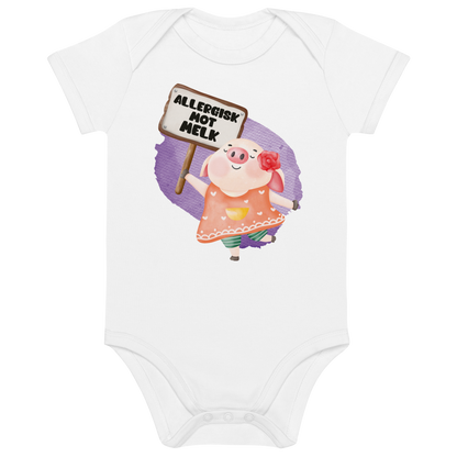 Hvit babybody som ligger flatt, med en glad gris som holder oppe et skilt med teksten "Allergisk mot melk". Foto.