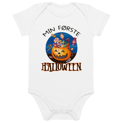 Hvit babybody som ligger flatt, med teksten "Min første halloween" og figur av en kurv som ser ut som et gresskar og som er fylt med godteri. Foto.