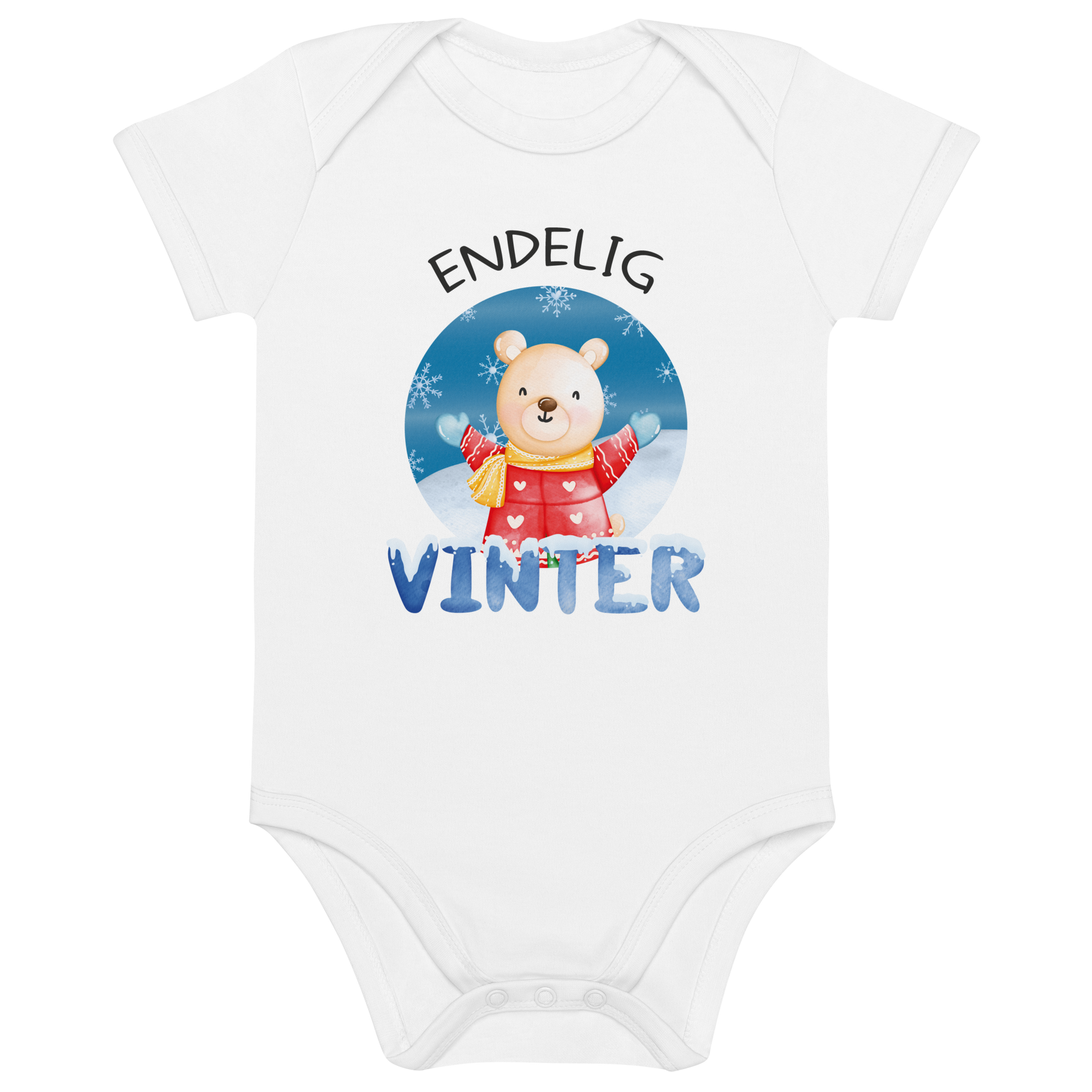 Hvit babybody som ligger flatt, med teksten "Endelig vinter" og figur av en lykkelig bamse i vinterklær som nyter snøen. Foto.