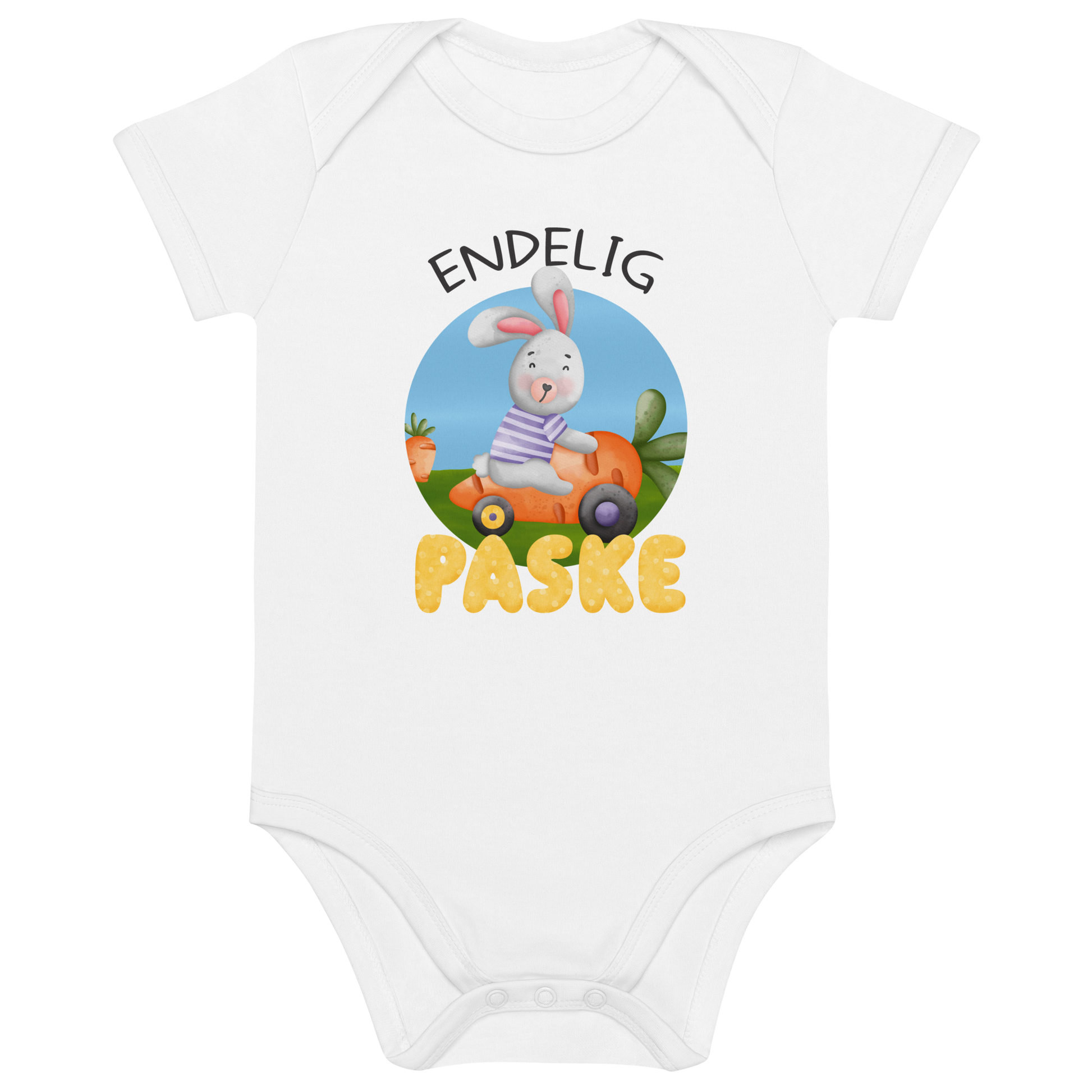 Hvit babybody som ligger flatt, med teksten "Endelig påske" og figur av en glad kanin som kjører en gulrotbil. Foto.