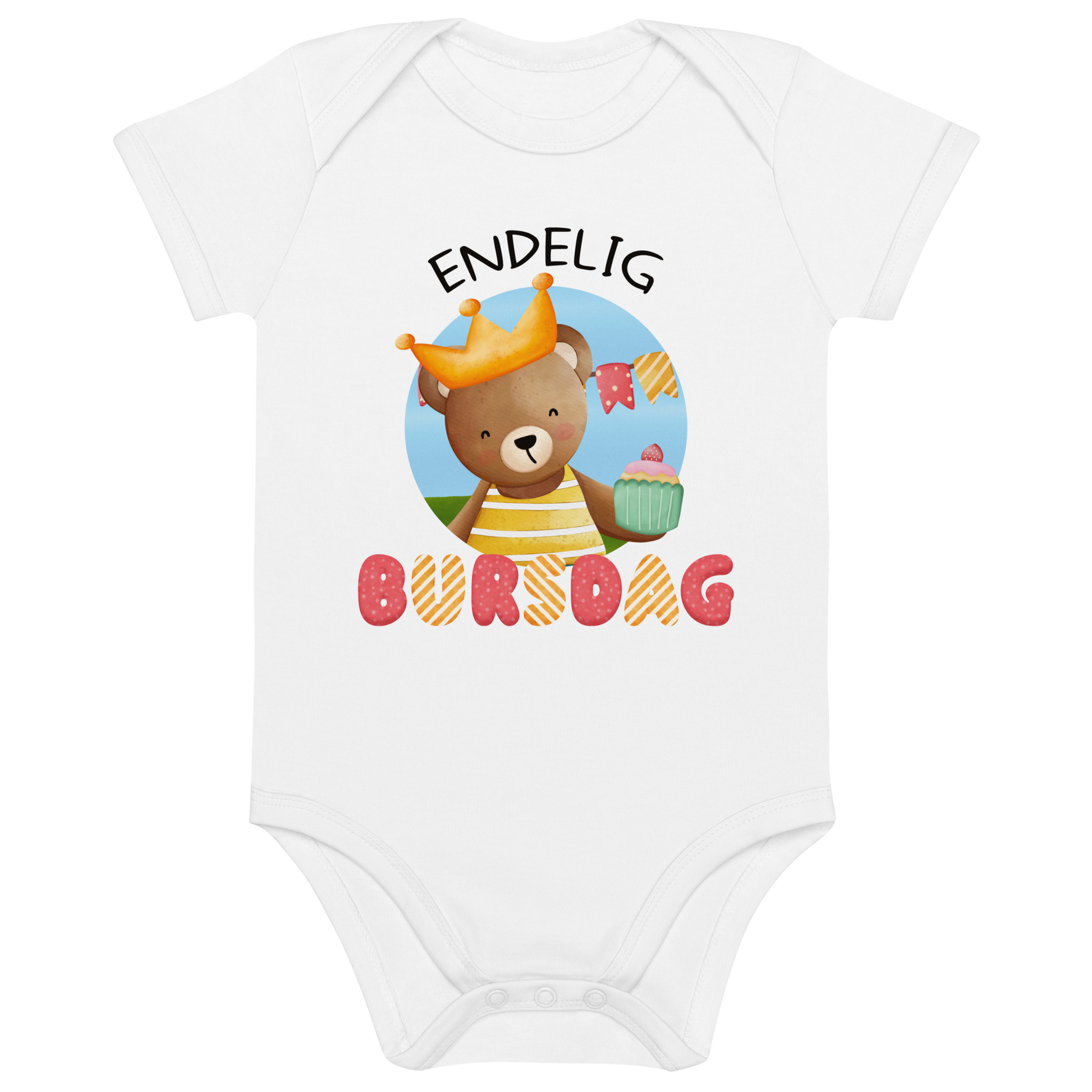 Hvit babybody som ligger flatt, med teksten "Endelig bursdag" og figur av en glad bamse som har på seg en krone og holder frem en muffin. Foto.