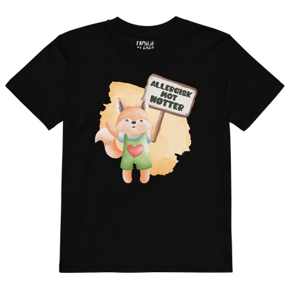 Svart t-skjorte som ligger flatt, med en glad rev som holder oppe et skilt med teksten "Allergisk mot nøtter". Foto.