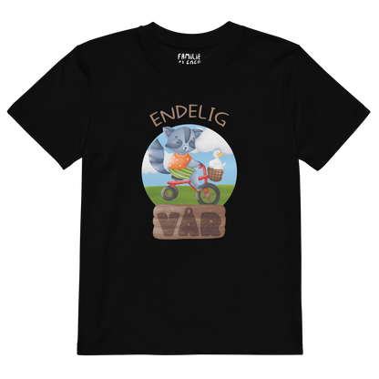 Svart t-skjorte som ligger flatt, med teksten "Endelig vår" og figur av en glad vaskebjørn på sykkel med en fornøyd gås i kurven på styret. Foto.