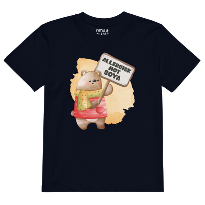 Mørkeblå t-skjorte som ligger flatt, med en glad bamse som holder oppe et skilt med teksten "Allergisk mot soya". Foto.