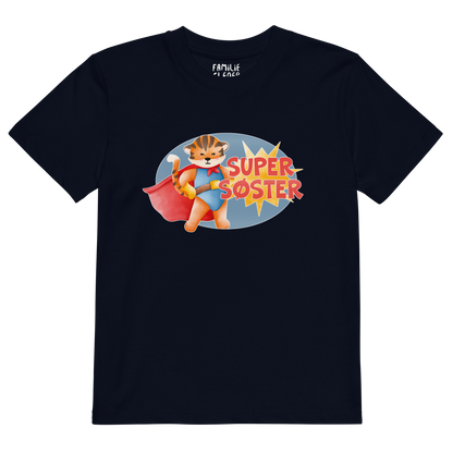 Mørkeblå t-skjorte som ligger flatt, med teksten "Supersøster" og figur av en stolt tiger i superhelt-klær. Foto.