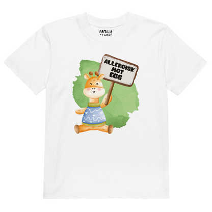 Hvit t-skjorte som ligger flatt, med en glad sjiraff som holder oppe et skilt med teksten "Allergisk mot egg". Foto.