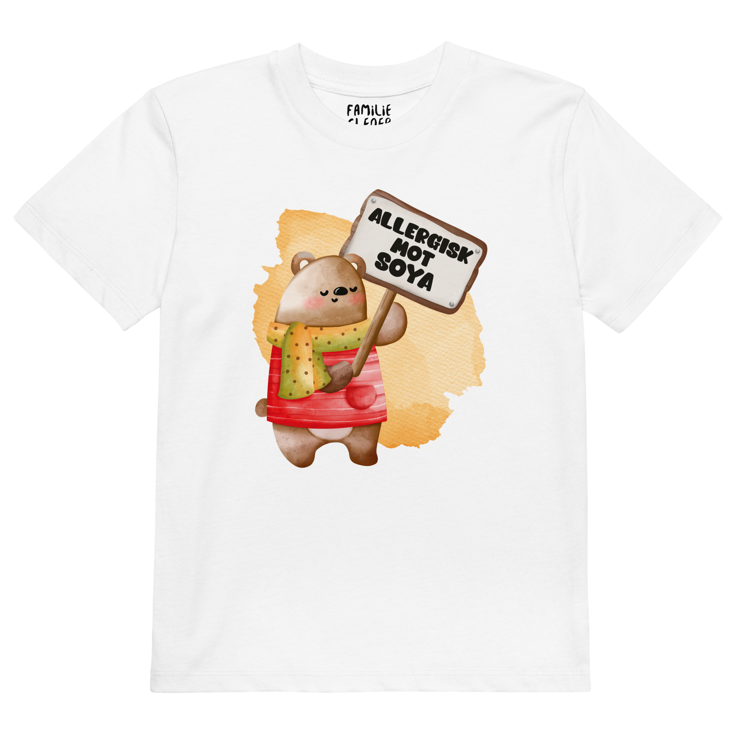 Hvit t-skjorte som ligger flatt, med en glad bamse som holder oppe et skilt med teksten "Allergisk mot soya". Foto.
