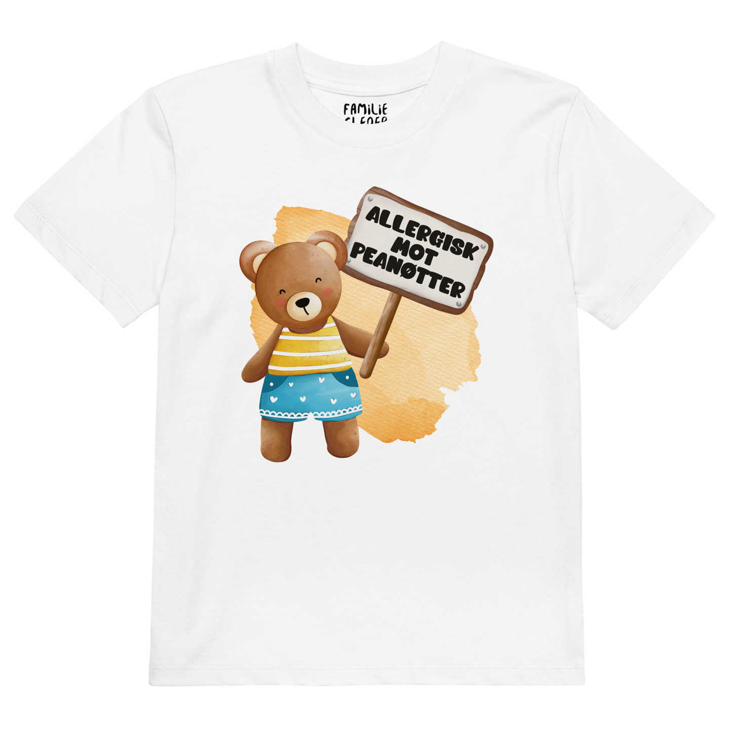 Hvit t-skjorte som ligger flatt, med en glad bamse som holder oppe et skilt med teksten "Allergisk mot peanøtter". Foto.