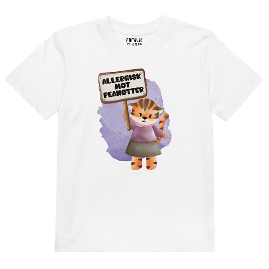 Hvit t-skjorte som ligger flatt, med en glad tiger som holder oppe et skilt med teksten "Allergisk mot peanøtter". Foto.
