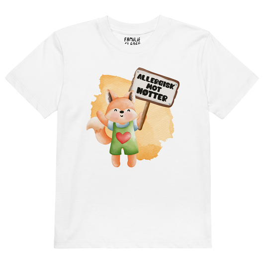 Hvit t-skjorte som ligger flatt, med en glad rev som holder oppe et skilt med teksten "Allergisk mot nøtter". Foto.