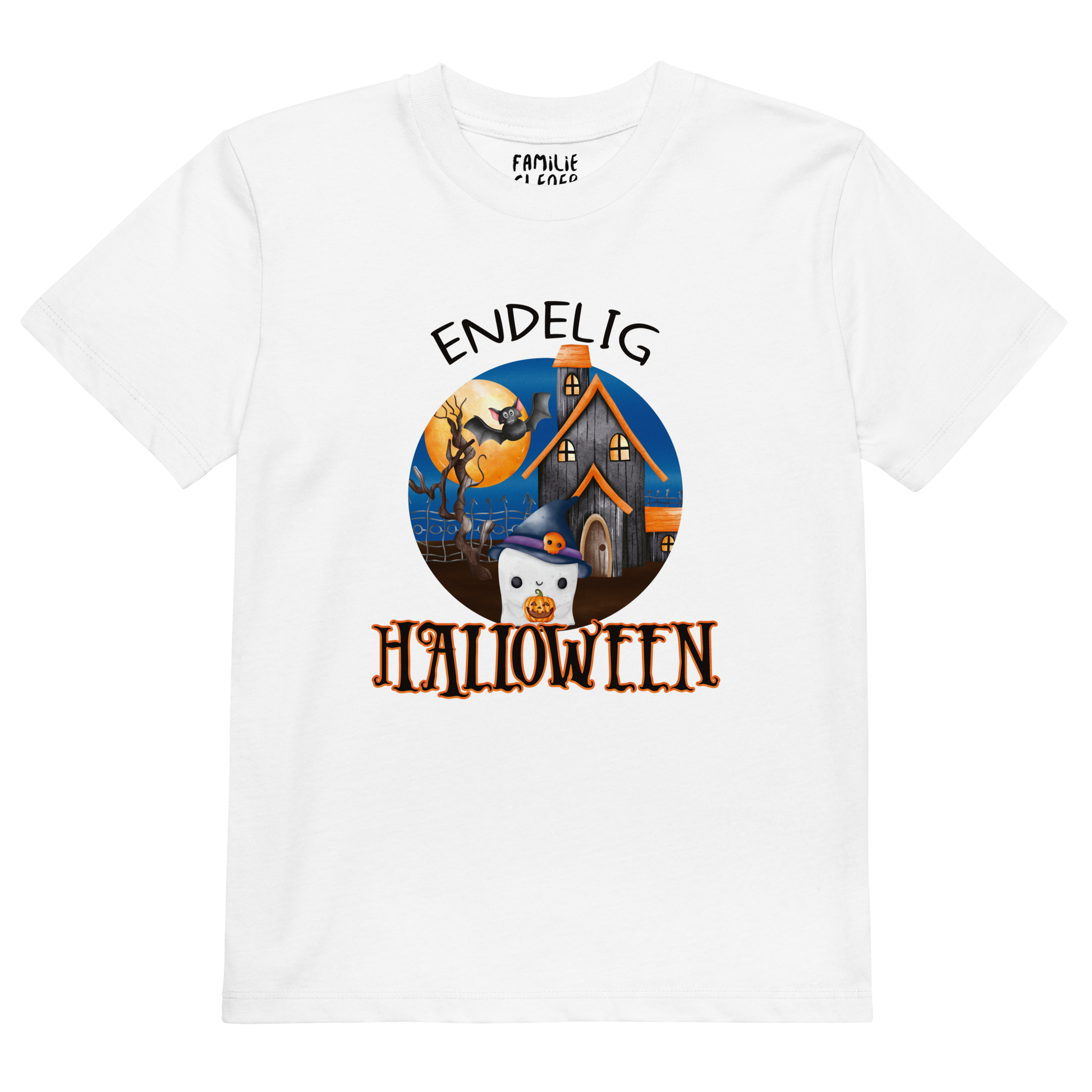 Hvit t-skjorte som ligger flatt, med teksten "Endelig halloween" og figur av et søtt spøkelse med heksehatt foran et hus med en stor fullmåne i bakgrunnen. Foto.