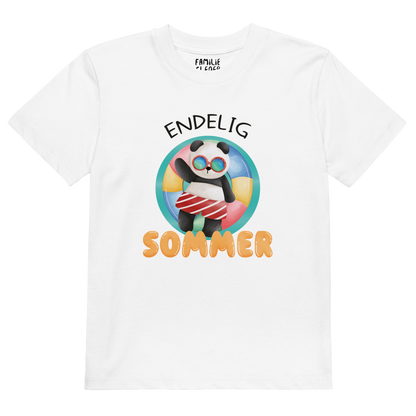 Hvit t-skjorte som ligger flatt, med teksten "Endelig sommer" og figur av en avslappet panda med solbriller som flyter i vannet på en badering. Foto.