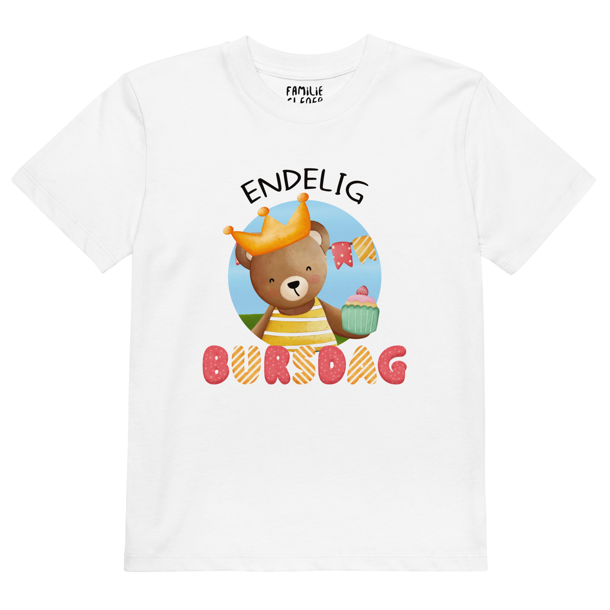 Hvit t-skjorte til barn som ligger flatt, med teksten "Endelig bursdag" og figur av en glad bamse som har på seg en krone og holder frem en muffin. Foto.