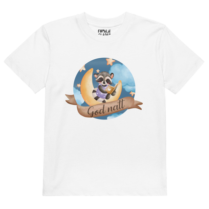 Hvit t-skjorte som ligger flatt, med teksten "God natt" og figur av en lykkelig vaskebjørn som sitter på månen og leser en bok. Foto.