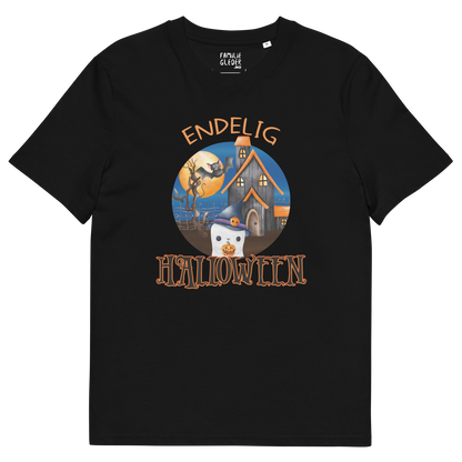 Svart t-skjorte som ligger flatt, med teksten "Endelig halloween" og figur av et søtt spøkelse med heksehatt foran et hus med en stor fullmåne i bakgrunnen. Foto.
