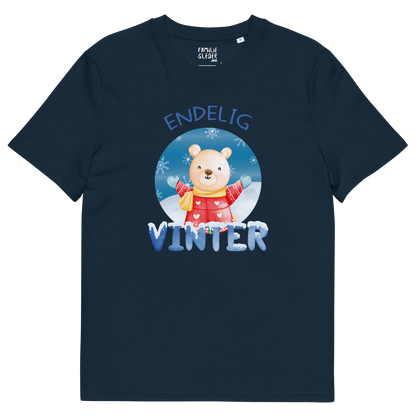 Mørkeblå t-skjorte som ligger flatt, med teksten "Endelig vinter" og figur av en lykkelig bamse i vinterklær som nyter snøen. Foto.