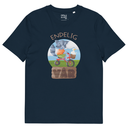Mørkeblå t-skjorte som ligger flatt, med teksten "Endelig vår" og figur av en glad vaskebjørn på sykkel med en fornøyd gås i kurven på styret. Foto.