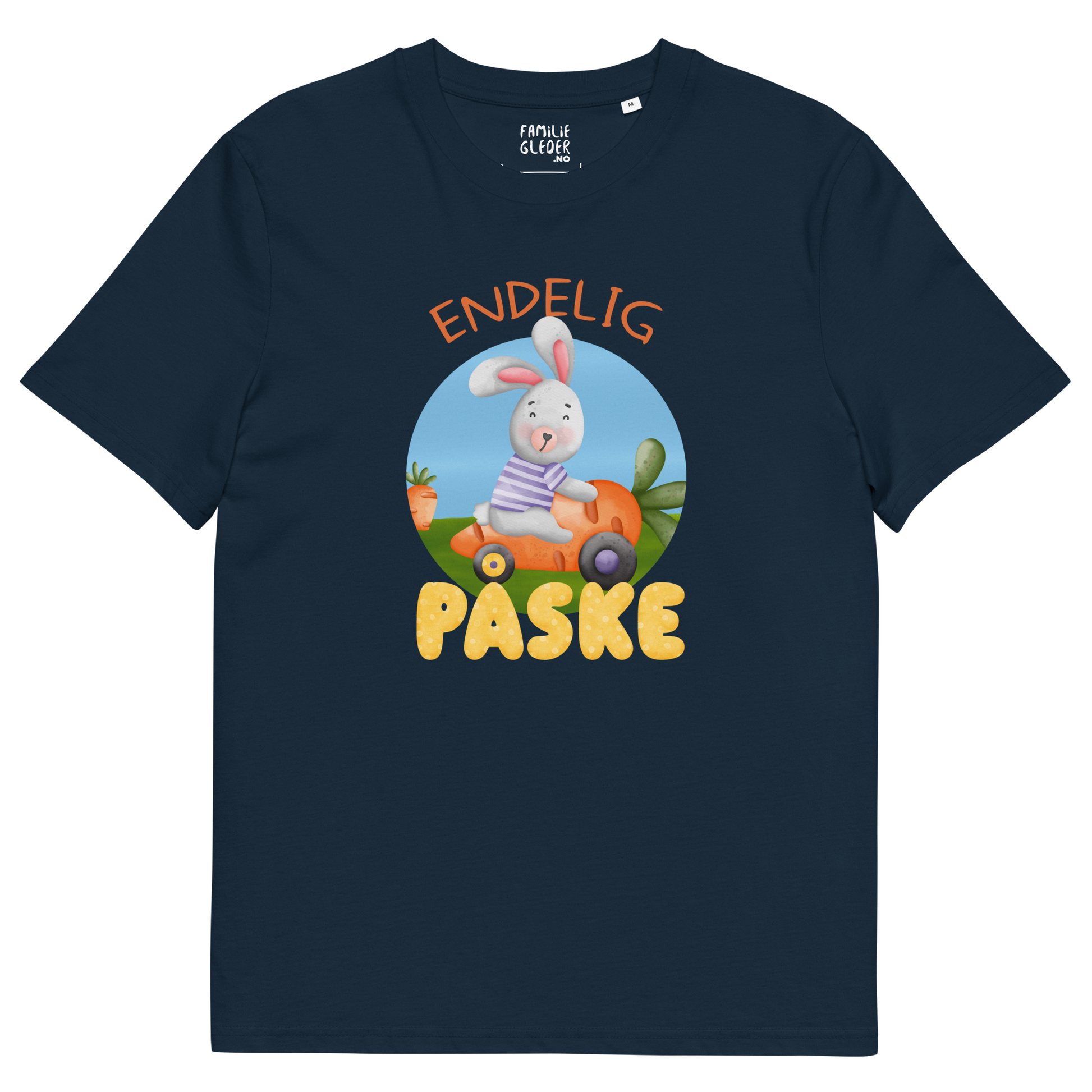 Mørkeblå t-skjorte som ligger flatt, med teksten "Endelig påske" og figur av en glad kanin som kjører en gulrotbil. Foto.