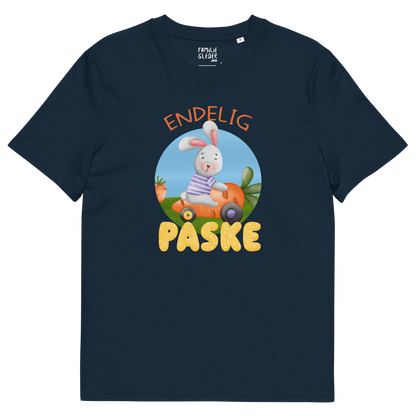 Mørkeblå t-skjorte som ligger flatt, med teksten "Endelig påske" og figur av en glad kanin som kjører en gulrotbil. Foto.