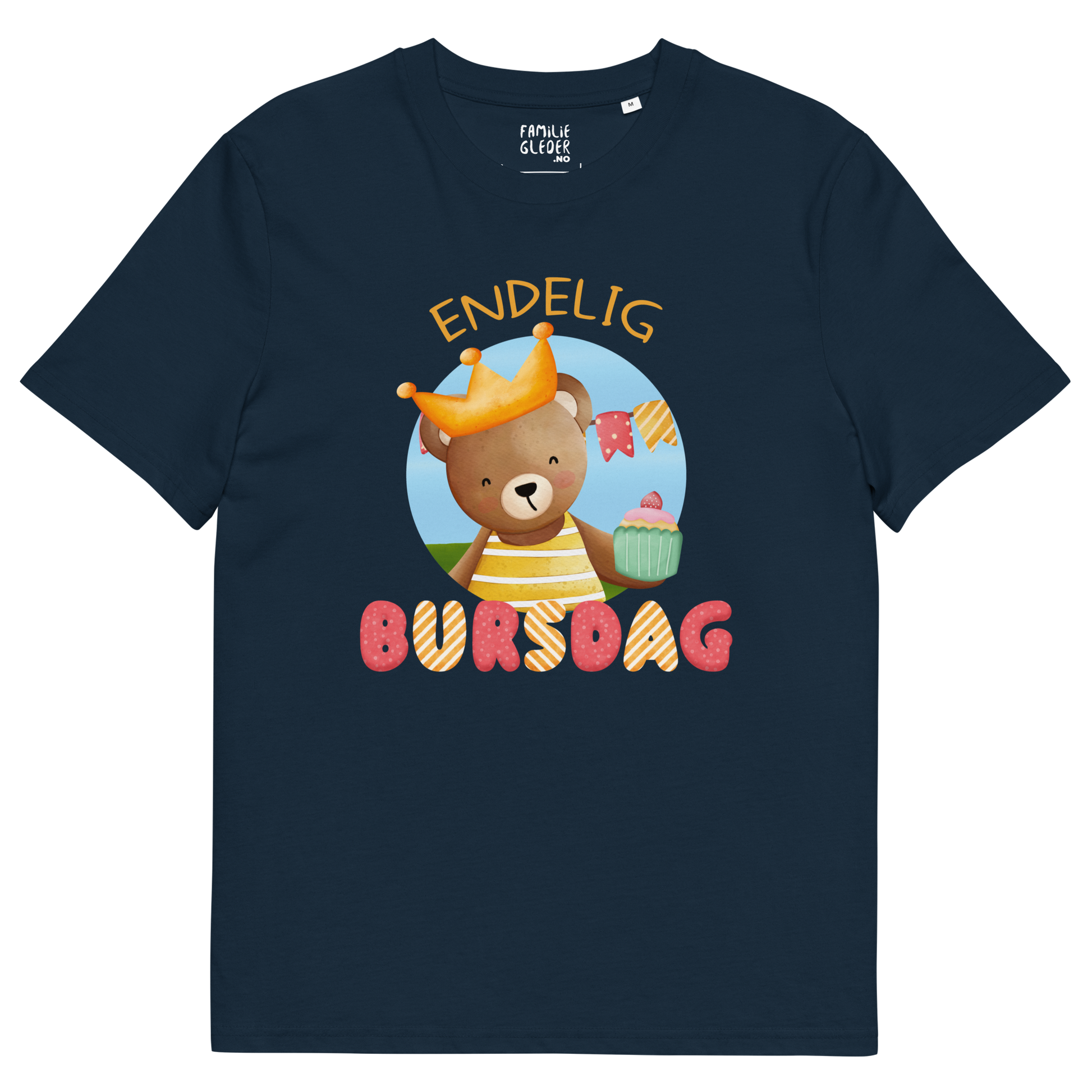 Mørkeblå t-skjorte som ligger flatt, med teksten "Endelig bursdag" og figur av en glad bamse som har på seg en krone og holder frem en muffin. Foto.