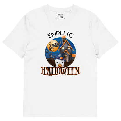 Hvit t-skjorte som ligger flatt, med teksten "Endelig halloween" og figur av et søtt spøkelse med heksehatt foran et hus med en stor fullmåne i bakgrunnen. Foto.