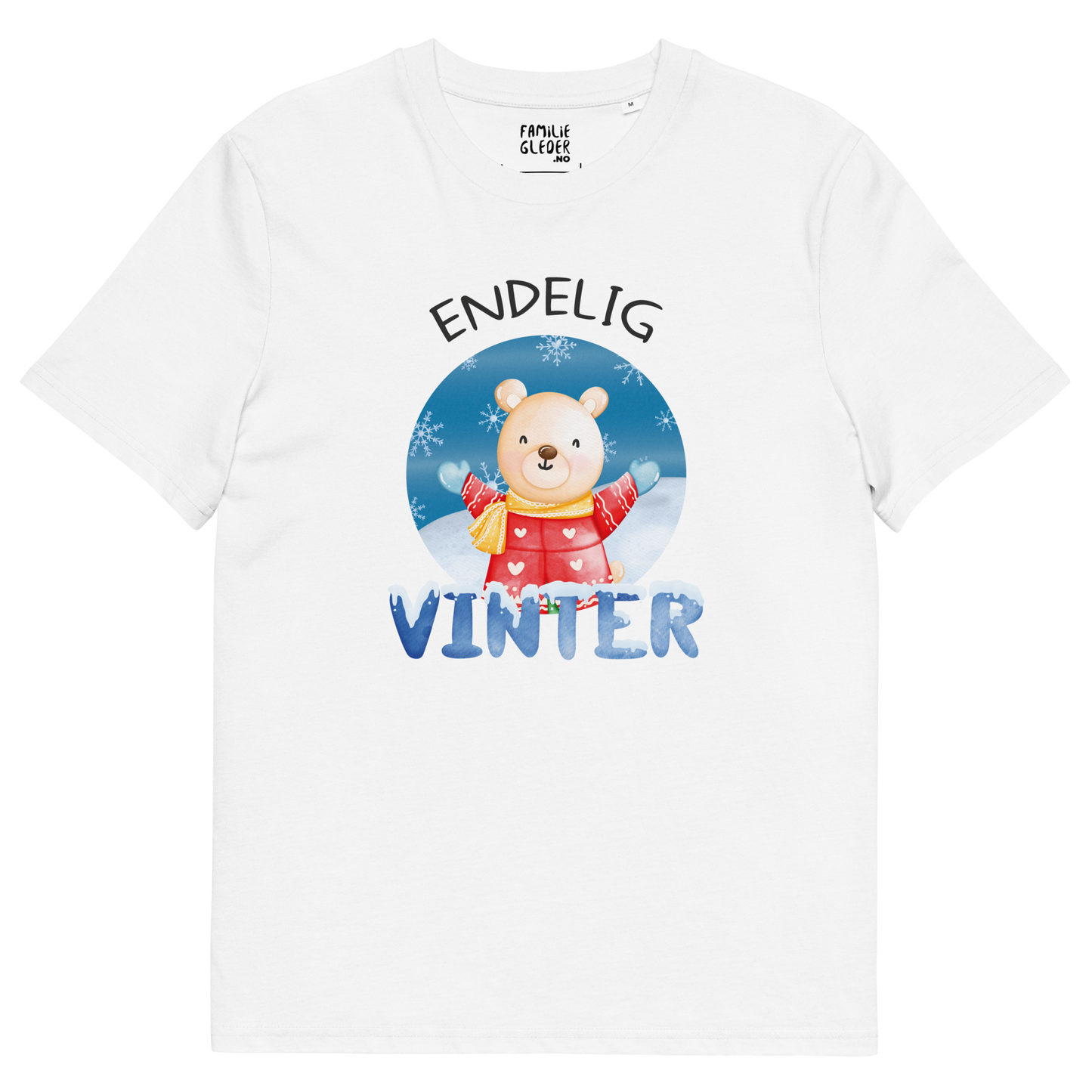 Hvit t-skjorte som ligger flatt, med teksten "Endelig vinter" og figur av en lykkelig bamse i vinterklær som nyter snøen. Foto.