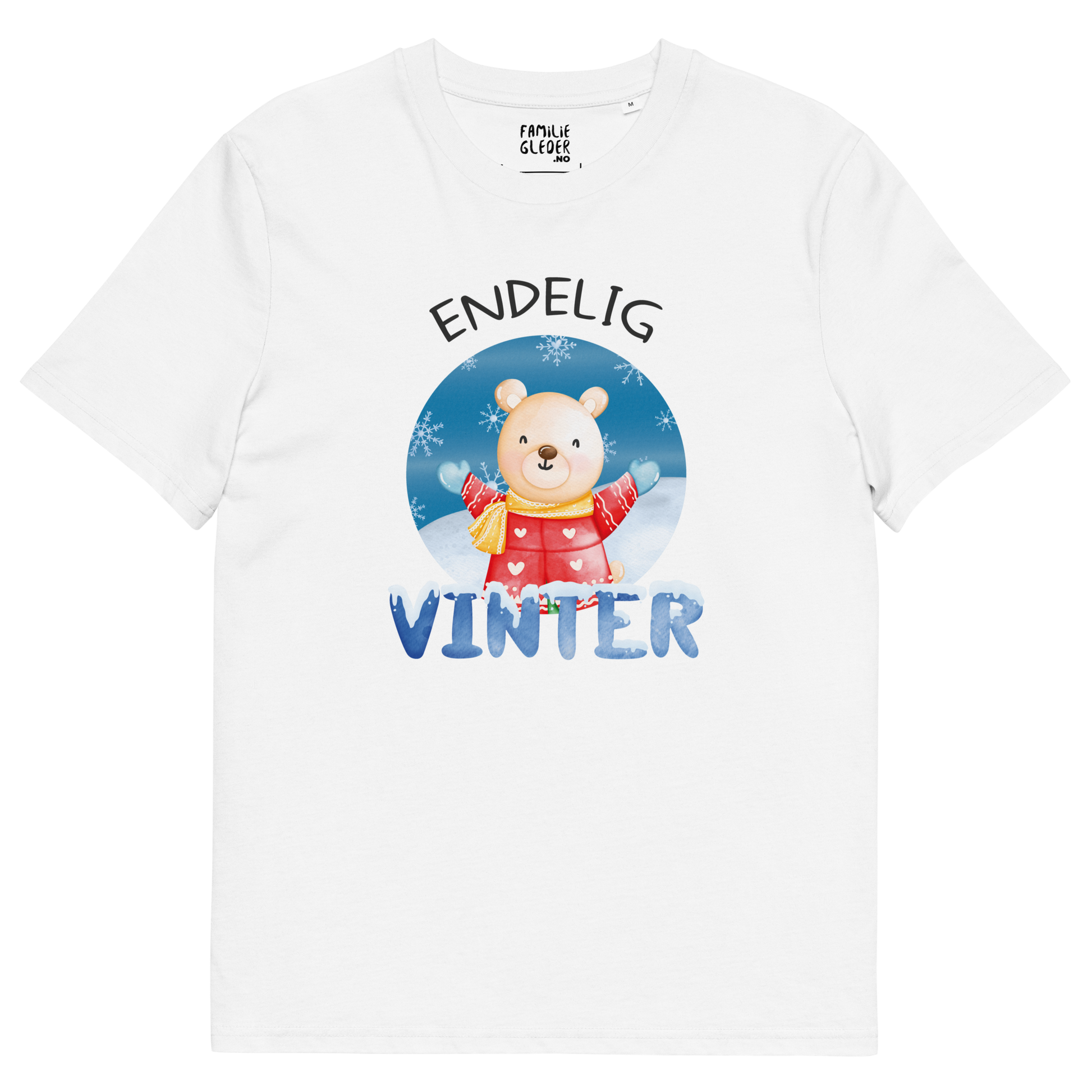Hvit t-skjorte som ligger flatt, med teksten "Endelig vinter" og figur av en lykkelig bamse i vinterklær som nyter snøen. Foto.